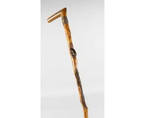 A JAPANESE CARVED RHINO HANDLE WALKING STICK, carved with frogs and alligator. 35ins long.