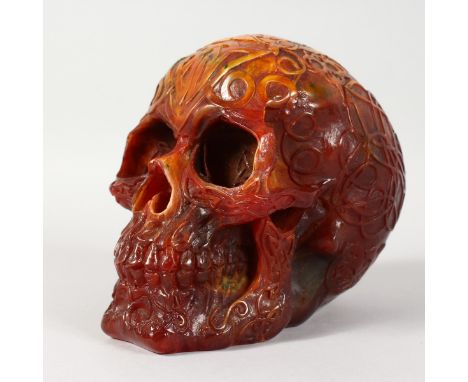 A LARGE AMBER STYLE MODEL OF A HUMAN SKULL. 7ins long.