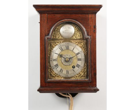 AN 18TH CENTURY OAK CASED HOODED WALL CLOCK, with an arched brass dial, silvered chapter ring, ornate spandrels, the arch wit