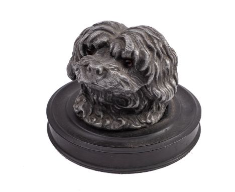 An inkwell in the form of a dog's head. The resin head with celluloid eyes hinged at the back opening to reveal the glass lin