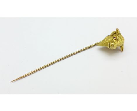 A yellow metal stick pin in the form of a bull's head, with red stone eyes