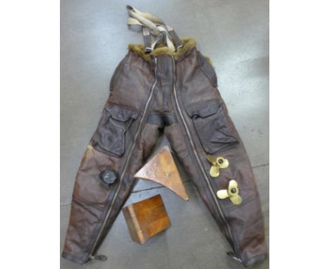 A pair of RAF WWII leather and sheepskin flying trousers, a pair of wooden chocks, a pair of 'trench art' type propeller cand