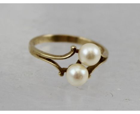 A 9CT GOLD RING, set with two cultured pearls, within a jeweller's ring box 