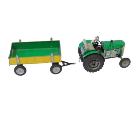 A modern tinplate clockwork tractor and trailer set, with key, painted in green with yellow trailer. 