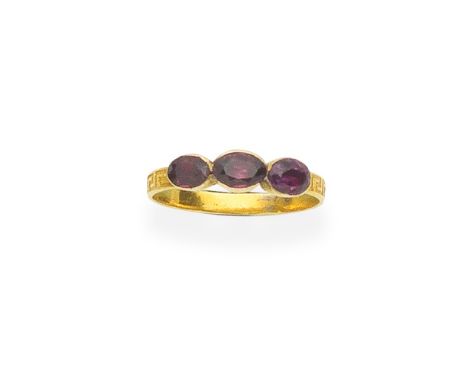 GARNET THREE-STONE RING, LAST QUARTER OF 19TH CENTURYSet with three oval-cut garnets, the hoop with engraved Greek key decora