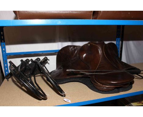 Leather E. Jeffries riding saddle, saddle racks, bridle hooks, snaffle bit, crop and whips, stirrup irons, cartridge belts, g