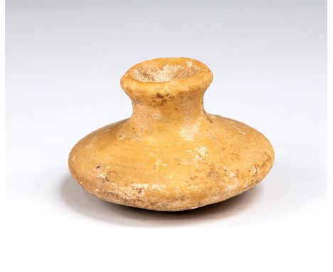 A buff pottery storage vessel of unusual squat disc shape with a short flaring mouth. Some small chips and general surface we