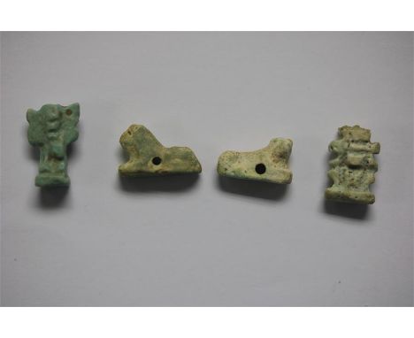 A mixed Egyptian Amulet group, Late Period, 664-332 BC.  A mixed group of faience amulets consisting of: two reclining lions;