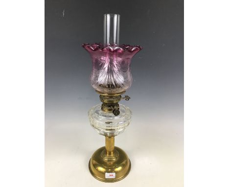 A Victorian brass columnar oil lamp with cut glass reservoir and achromatizing glass globe