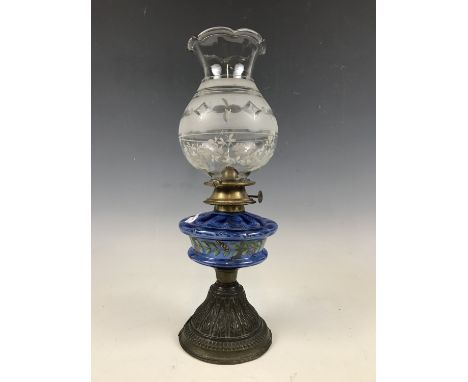 A Victorian oil lamp having a hand-enamelled blue glass reservoir and cut-glass shade, 40 cm