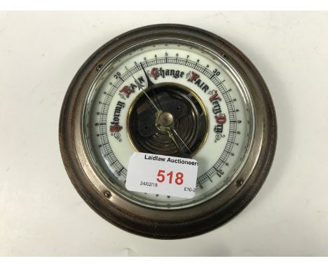 An oak cased barometer with an enamelled face
