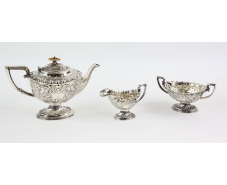 Edward VII silver three-piece tea service, on spiral fluted oval feet and profusely decorated with scrolls, by W.M &amp; Co.,