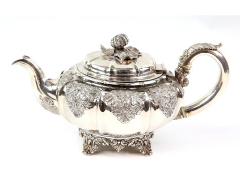 George IV silver teapot, by J E Terrey &amp; Co, London 1829, the body embossed with leaves and the cover engraved with a mon