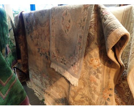 Thick pile fringed Chinese carpet with designs of flora against a pink ground approximately 11' x 9' and a smaller example