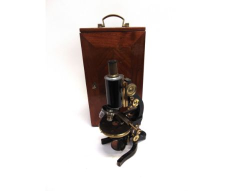 AN E. LEITZ MONOCULAR MICROSCOPE  serial no. 109409, with a selection of lenses, in a mahogany storage / travel case. 
