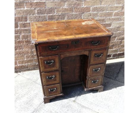 AN 18TH CENTURY WALNUT KNEEHOLE DESK  with herringbone inlay, the rectangular top with re-entrant front corners, above single