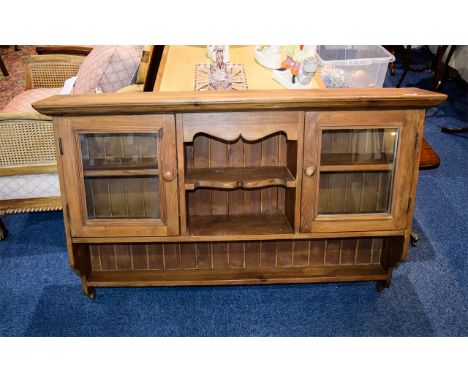 A Large Pine Wall Cabinet Rustic stained pine wall unit with two small glazed cupboards, three small central shelves and larg