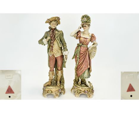 Royal Dux Large Pair of Figures In 18th Century Dress, The Lady In a Pink Dress Which She Holds up to Show a Pale Green Under