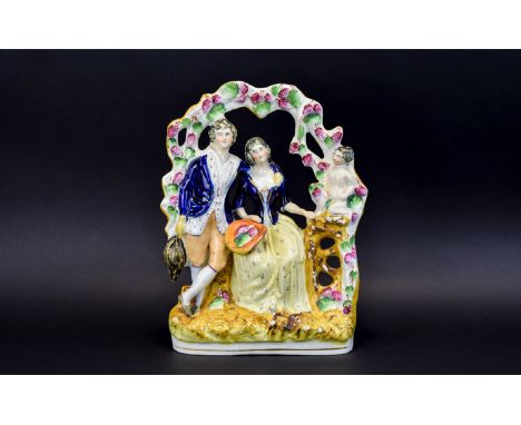 Staffordshire Arbour Group Figure of Two Lovers. c.1860. He Stands Wearing an Open Neck Shirt, Jacket, Long Waistcoat and Kne