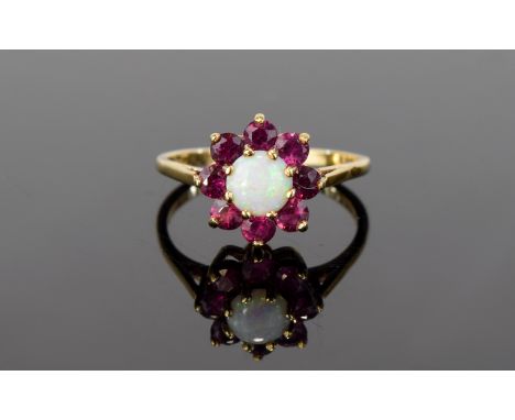 9ct Gold Opal and Ruby Ring. Flowerhead setting with impressive central opal cabouchon surrounded by eight faceted rubies