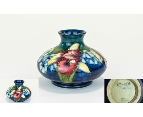 W. Moorcroft Signed Tube lined Squat Vase ' Orchids ' Pattern on Blue Ground. Signed W. Moorcroft to Base. c.1930's. Height 3