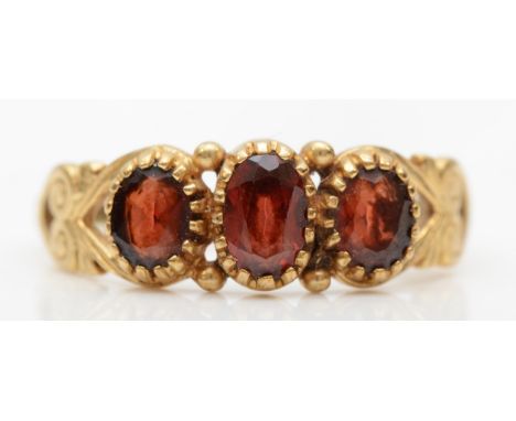 A vintage 9ct garnet three stone ring, V, 2.1gm. 