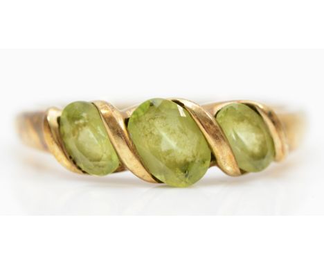 A 9ct gold peridot three stone dress ring, T, 3gm. 