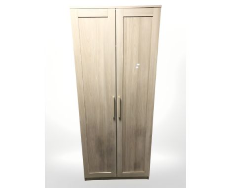 A John Lewis four-piece light oak bedroom suite comprising af double-door wardrobe, width 78 cm, a pair of bedside stands, wi