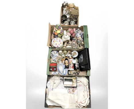 Four boxes containing lace, linen, tankards, a mantel clock, china figures and ornaments, etc.