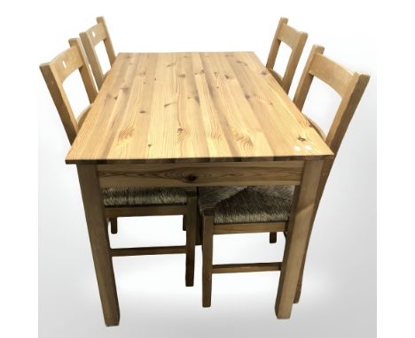 A contemporary pine dining room table, width 120 cm and four pine rush-seated ladder back chairs.  (5)  