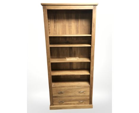 A light oak bookcase fitted with two drawers, width 90 cm, height 199 cm.