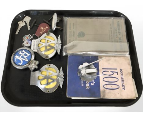 A group of vintage car badges, AA, RAC, Wolseley, owners drivers manual for a Wolseley 1500 and a Morris Minor operation manu