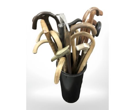 A quantity of wooden walking sticks, a climbing axe, umbrella, etc.