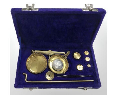 A set of brass sovereign scales in case, with weights.