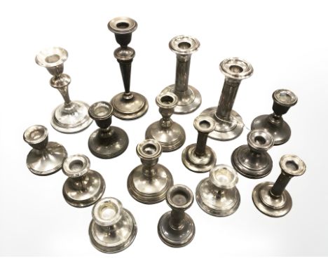 A collection of silver candlesticks including some pairs.
