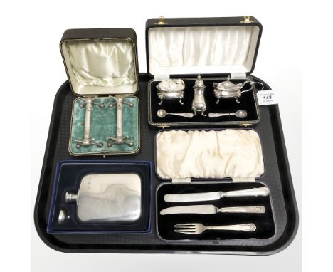 A three piece silver plated condiment set, cased, together with a pair of antique knife rests, a silver plated hip flask, etc
