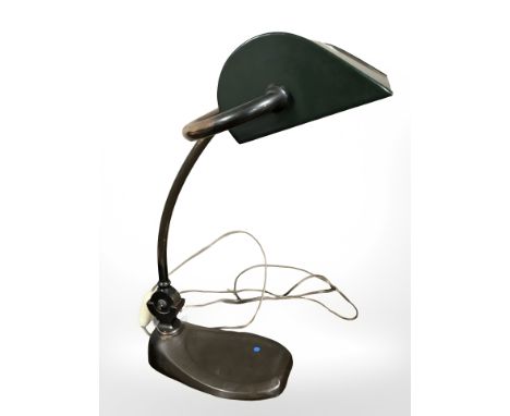 An antique copper banker's lamp with metal shade.