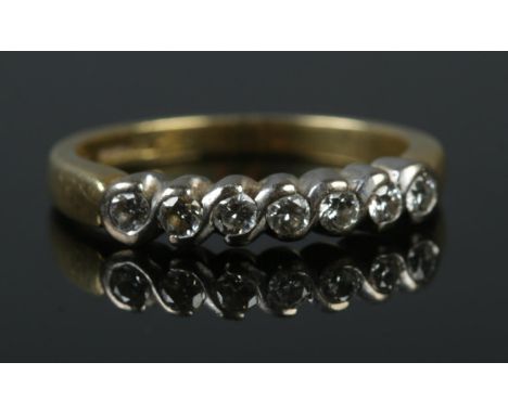 An 18ct gold and seven stone diamond ring. Sponsor mark for Fred E Ullman. Size O. 4.24g.  