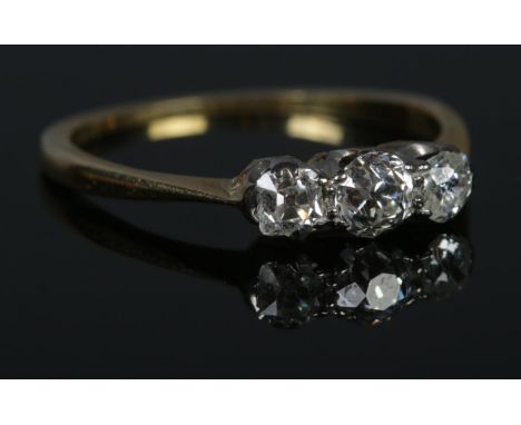 An 18ct Gold and three stone old cut diamond ring, with the largest stone just under Â¼ct. Size O. Total weight: 2.0g  