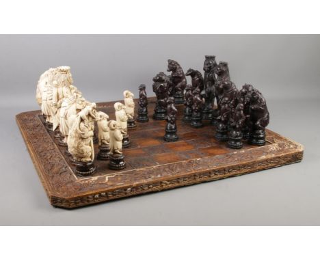 A Reynard the Fox inspired resin chess set, with cream and dark brown pieces. Complete, with information leaflet, on carved b