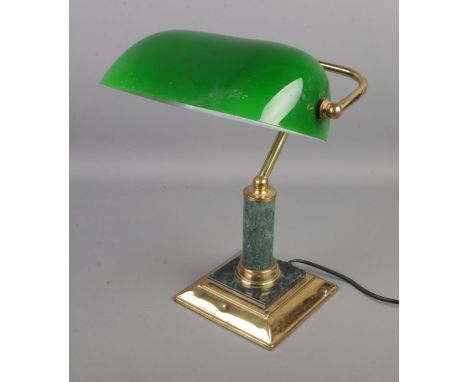 A vintage brass desk lamp with green glass shade.  