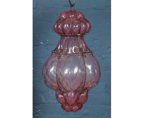 A pink blown glass and wirework hanging light.  Glass in good condition. Wire work slightly rusted.