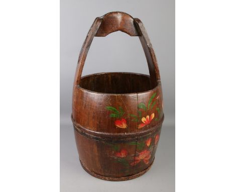 A vintage wooden well bucket with metal mounts.  