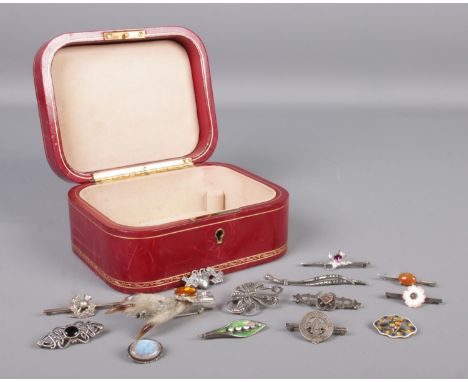 An L. Mannelli red leather jewellery box containing fourteen vintage and Victorian silver brooches, to include thistle, pheas