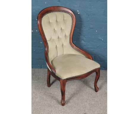 A mahogany balloon back chair with deep button studded upholstery.  