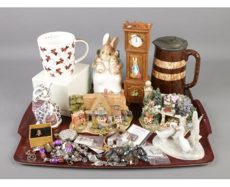 A tray of ceramics and costume jewellery. Includes Border Fine Arts Peter Rabbit Clock, Lilliput Lane Peaceful Pastimes, Nao,