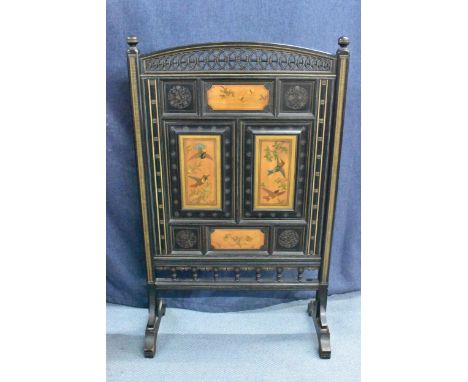 A Victorian Aesthetic movement ebonised firescreen, the top having two turned finials and pierced roundels above four panels 
