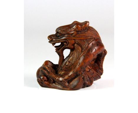 A carved fruitwood netsuke of a dragon