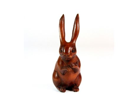 A carved fruitwood netsuke of a hare with onyx eyes H 7cm