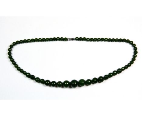 A single strand necklace of graduated dark green jade beads